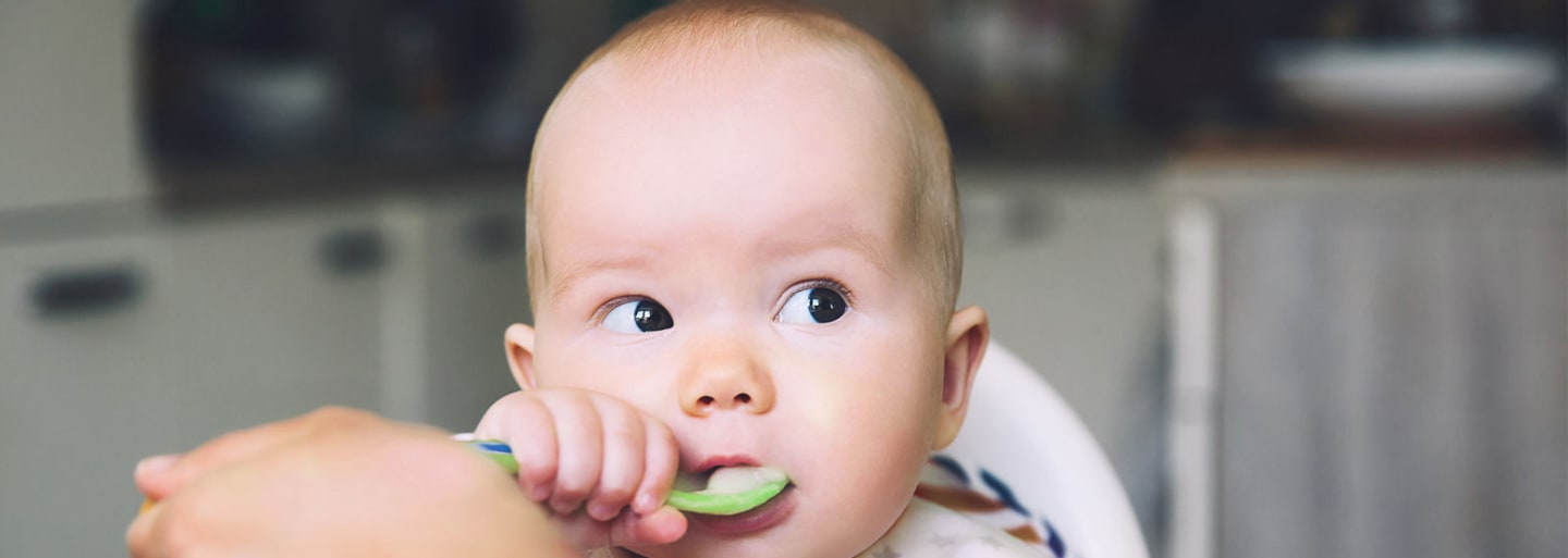 Baby spiser puré med ske