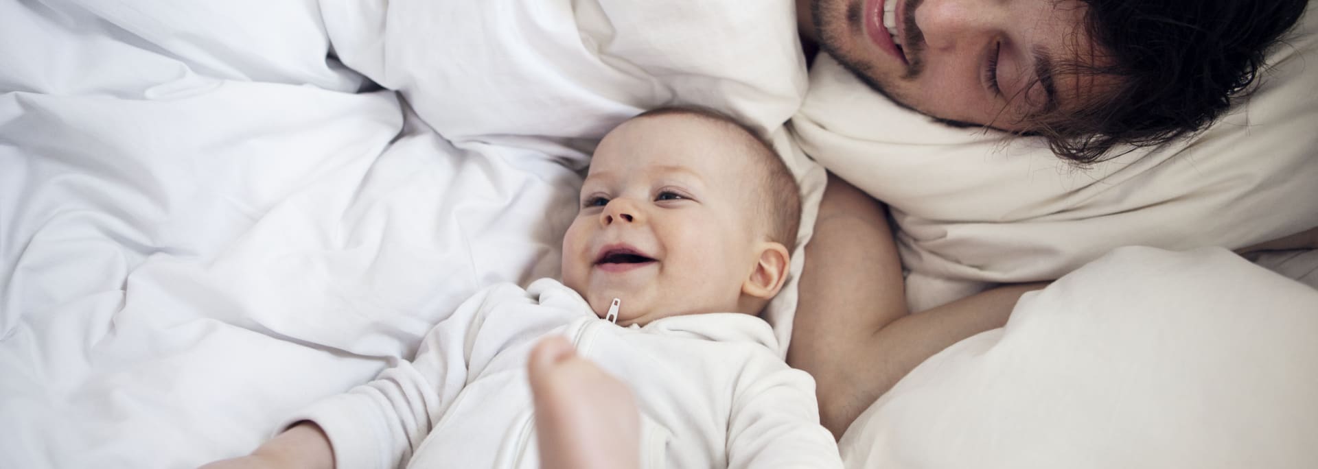 Baby og forælder i dyner