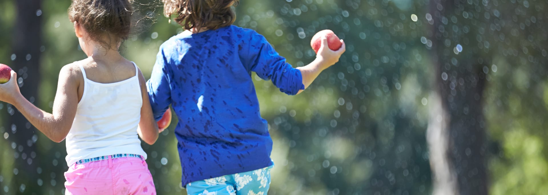 To børn i sommertøj der leger i parken