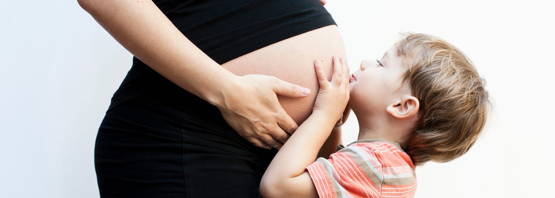 Gravid kvinde og barn der kigger på maven