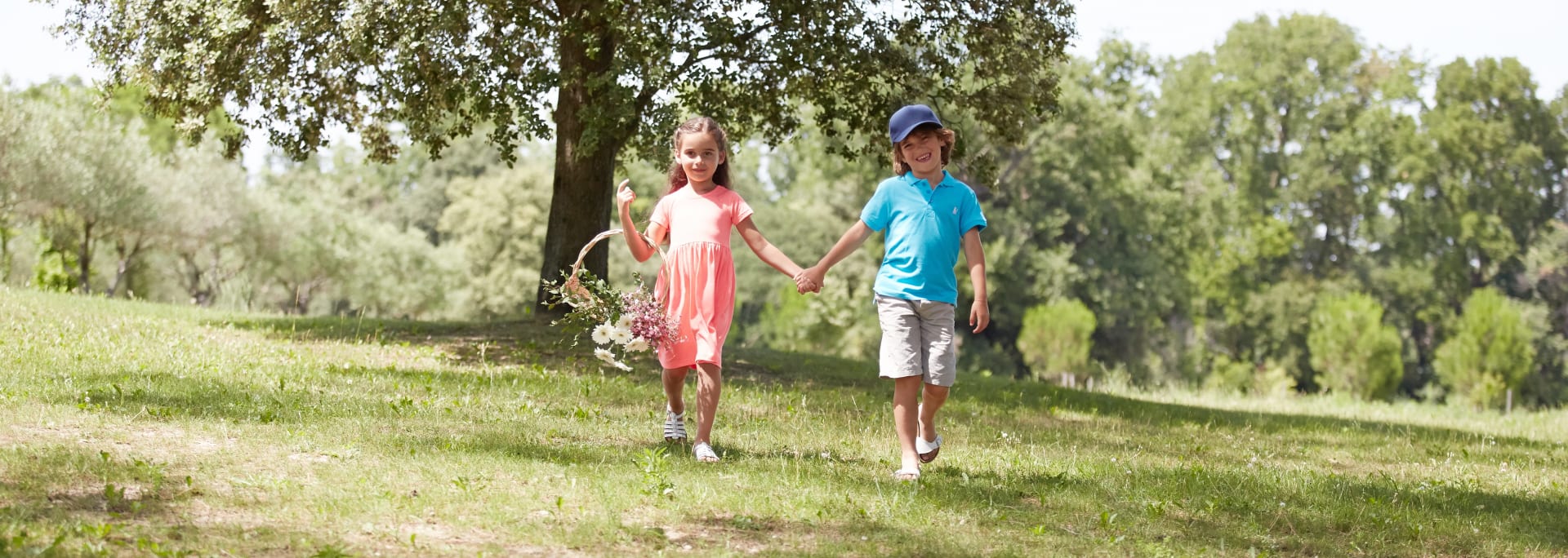 Børn der leger på en græsplæne under et træ