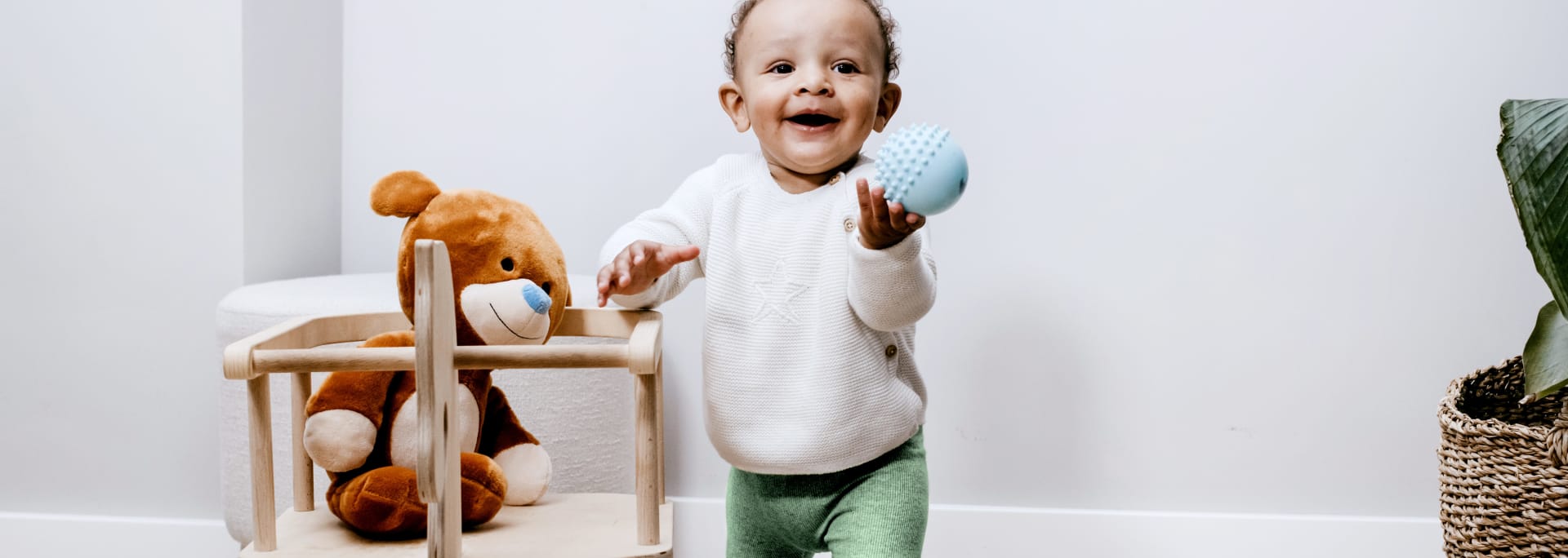 Barn der står op ved en babystol