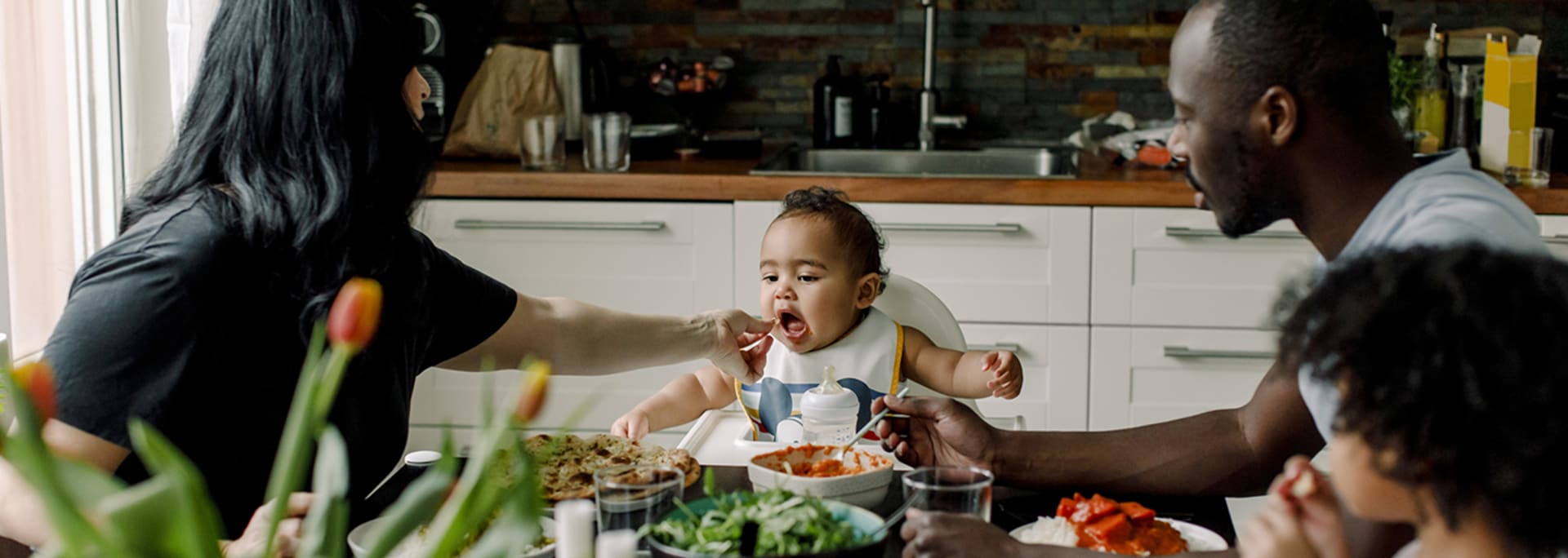 Familie sidder om bord og spiser