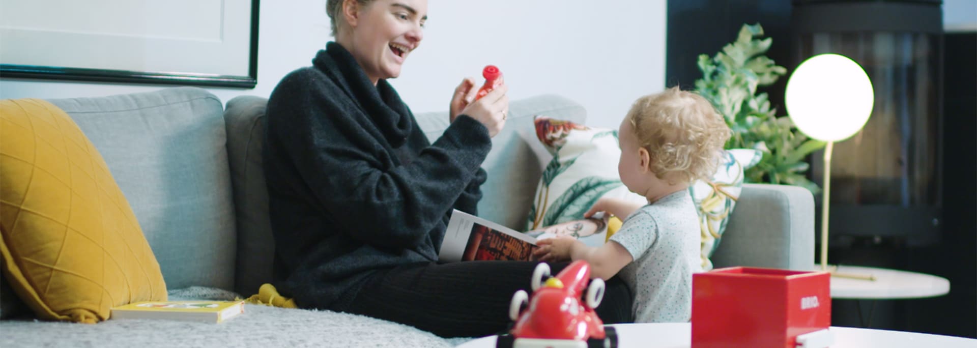 Mamma leker med sitt barn i vardagsrummet