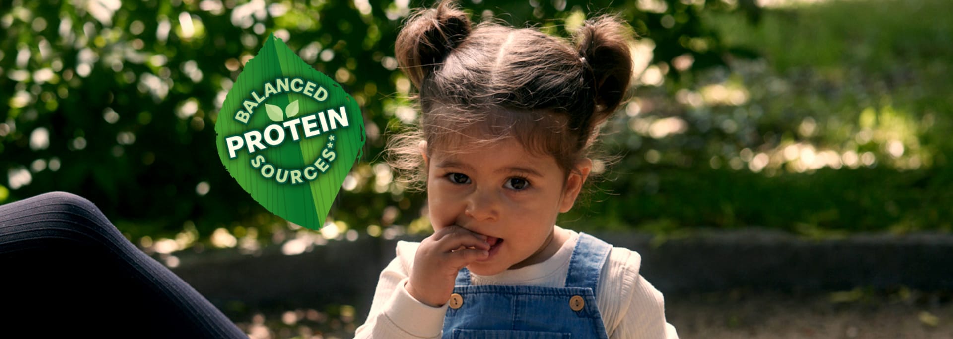 Pige spiser noget, logo: afbalancerede proteinkilder