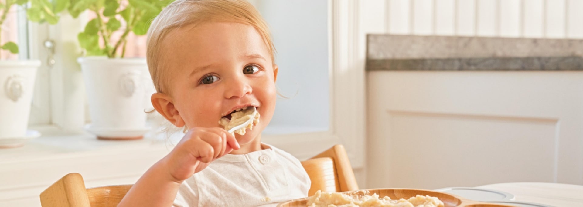 Baby der spiser grød med ske