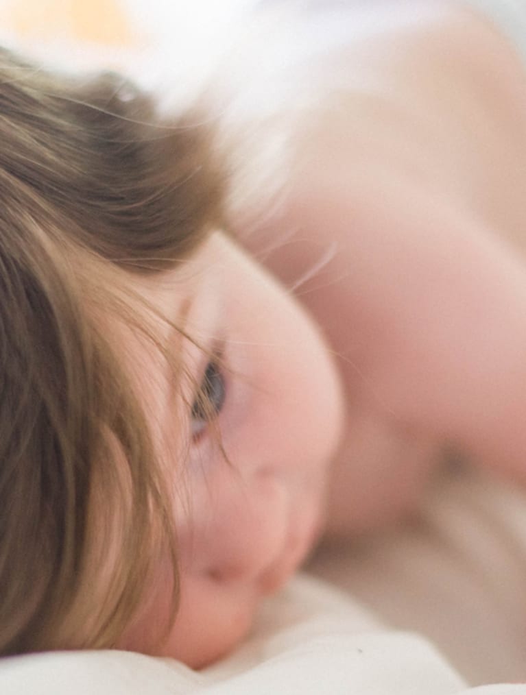 Barn som vilar med huvudet på ett lakan