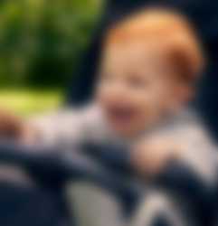 barn der sidder i en klapvogn og griner