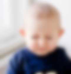 Baby der laver en grimasse af noget den har spist