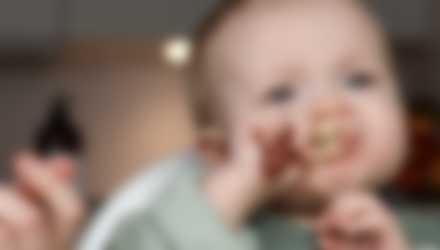 Baby der spiser med ske