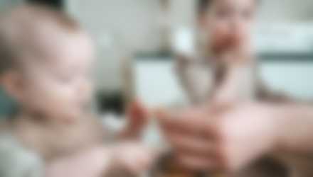 Et barn der bliver madet og et større barn der spiser