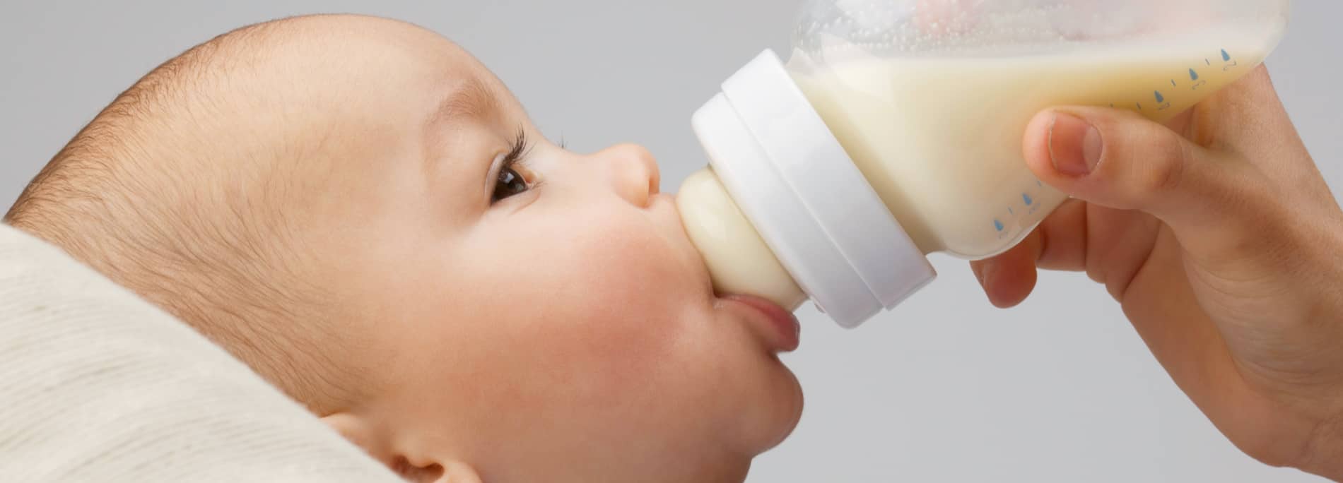 Fije Con El Pequeño Bebé Lindo Con La Botella De Leche. Bebé Recién Nacido  En Pijamas De Color Rosa Beber Leche .. Alimentación De Recién Nacido Con  Fórmula O Leche Materna. Sonrisa