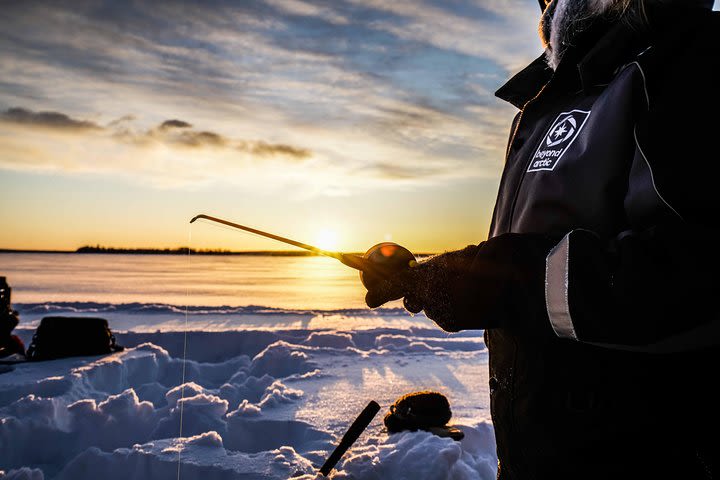 Ice fishing on a frozen lake image