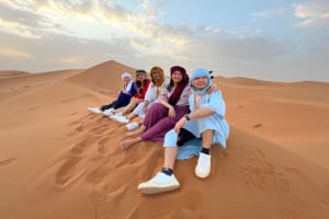 Our clients enjoying the sunset on the dunes of Merzouga desert during the Marrakech tour 4 days