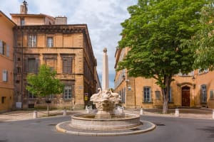 Stone fountain in small square surrounded by historic mansions in Aix-en-Provence