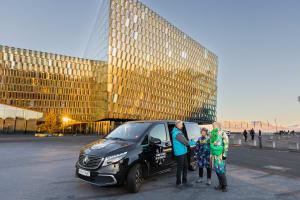 A guide from Your Friend in Reykjavik meeting travellers outside the Harpa Concert Halll in Reykjavik 