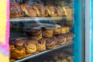A picture of freshly baked pastries in a shop window. 