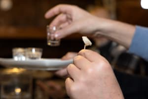 A bite of fermented shark and a small snaps glass going together as experience
