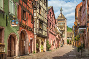 Historic street of Riquewihr village lined with colorful houses and shops