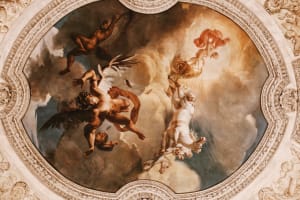 An ornate painted ceiling inside the Louvre Museum