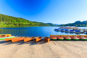 Wooden boats on Mummelsee Lake surrounded by Black Forest mountains during a day trip from Strasbourg