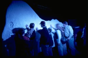 People touching a mini iceberg at Titanic