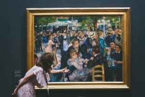 Museum visitors viewing a framed Impressionist group scene at Musée d’Orsay