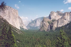 Yosemite Valley panoramic view showing El Capitan and Bridalveil Fall surrounded by granite cliffs and forest