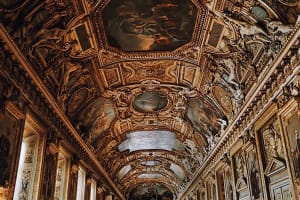 An ornate gilded ceiling in a Louvre Museum gallery