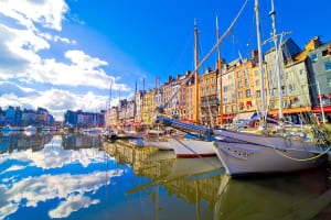 Colorful tall houses reflected in the water of Honfleur’s Vieux Bassin