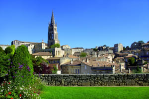 Panoramic view of Saint-Émilion UNESCO village golden limestone buildings with iconic bell tower surrounded by vineyards