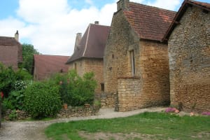 Traditional stone houses and a flower-filled garden in the village of Saint-Léon-sur-Vézère in the Dordogne, France.