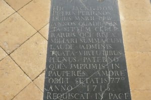 Dom Pérignon’s dark stone grave slab with a Latin inscription in the tiled floor of Hautvillers’ abbey church.
