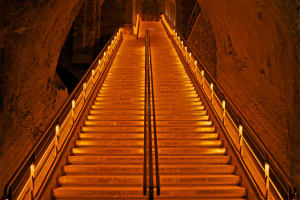 Illuminated staircase descending through Veuve Clicquot’s historic Champagne cellars in Reims.
