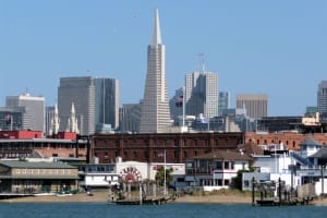 San Francisco waterfront with Transamerica Pyramid and skyline viewed from the bay, showing historic pier buildings