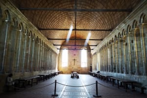 Interior nave of Mont Saint Michel abbey church with high stone pillars