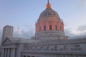 San Francisco City Hall dome illuminated at dusk with classical architecture and columns visible