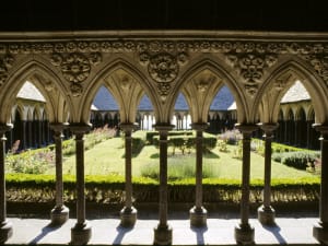Gothic cloister of Mont Saint Michel abbey with stone arches and garden