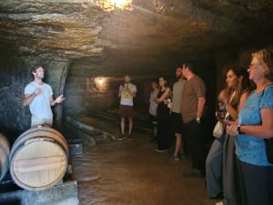 Underground limestone cellar used for aging Saint-Émilion wines visited during a full-day tour from Bordeaux