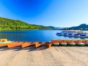 Wooden boats on Mummelsee Lake surrounded by Black Forest mountains during a day trip from Strasbourg