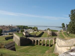 Panoramic view of Blaye citadel, green ramparts and the Gironde estuary with town and river in the background