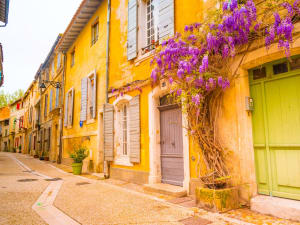 Narrow stone street in Saint‑Rémy de Provence with cafés and boutiques