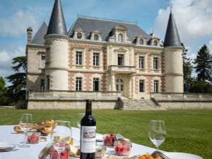 Elegant picnic setup with French charcuterie, cheese, and wine in Château Lamothe Bergeron vineyard gardens