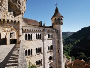 Cliffside sanctuary building and tower of Rocamadour overlooking the green Alzou valley in France