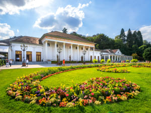Kurhaus Baden‑Baden with colorful flower beds and green lawn in front
