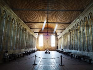 Interior nave of Mont Saint Michel abbey church with high stone pillars
