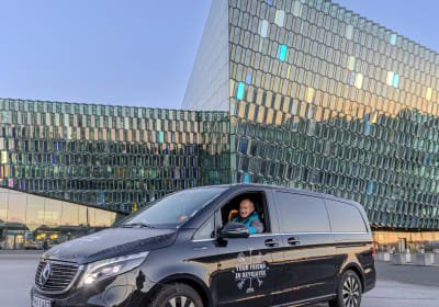 A tour vehicle being driven by a Guide from Your Friend in Reykjavik in front of the Harpa Concert Hall in Reykjavik 