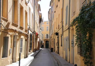 Quiet narrow street lined with pastel townhouses in Aix-en-Provence