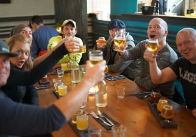 A Beer & Booze tour group performing the Skál gesture