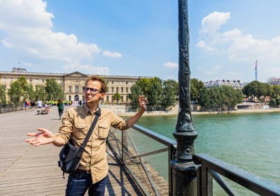 Guide explaining Paris landmarks beside the Seine River